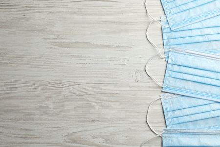 Protective masks on wooden background, flat lay with space for text. safety equipmentの写真素材