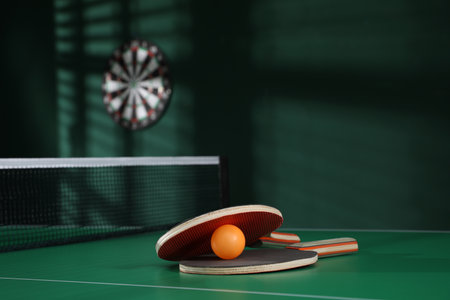 Rackets and balls on green table indoors. Space for textの写真素材