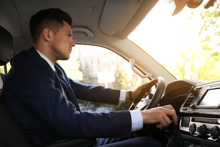 Handsome man driving his modern luxury car
