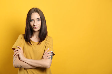 Portrait of pretty young woman with gorgeous chestnut hair on yellow background, space for textの写真素材