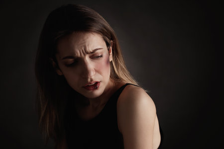 Woman with facial injuries on black background, space for text. domestic violence victimの写真素材
