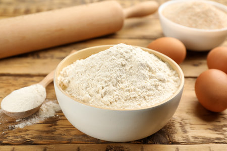 Wheat flour in bowl on wooden tableの写真素材