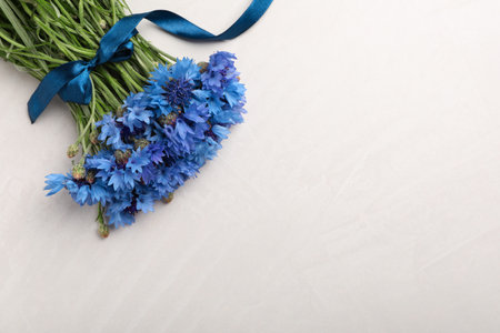 Bouquet of beautiful cornflowers on light table, top view. Space for textの写真素材