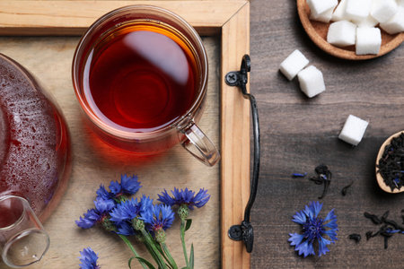 Flat lay composition with tea and cornflowers on wooden tableの写真素材