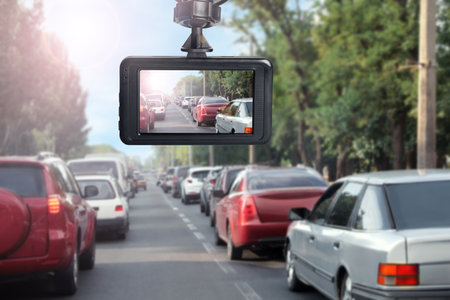 Modern dashboard camera mounted in car, view of road during drivingの写真素材