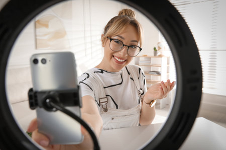 Blogger recording video at home, view through ring lampの写真素材