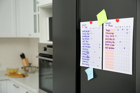 To do lists and sticky notes on fridge in kitchen. Space for textの写真素材