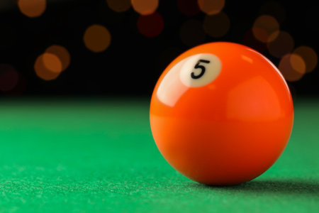 Billiard ball with number 5 on green table, closeup. Space for textの写真素材