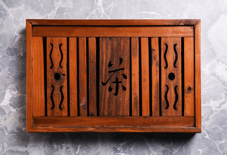 Wooden tray with Chinese hieroglyph meaning Tea for traditional tea ceremony on light grey marble table, top viewの写真素材