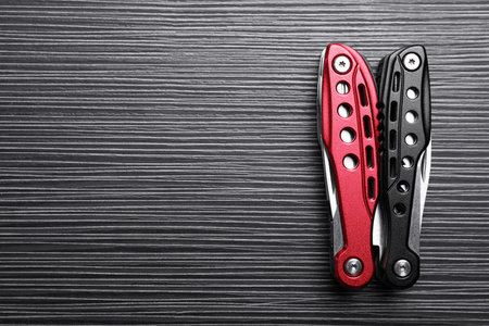 Modern compact portable multitool on black wooden table, top view. Space for textの写真素材