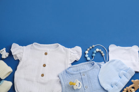 Flat lay composition with baby clothes and accessories on blue background, space for textの写真素材