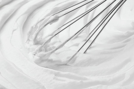Whipping white cream with balloon whisk, closeup viewの写真素材