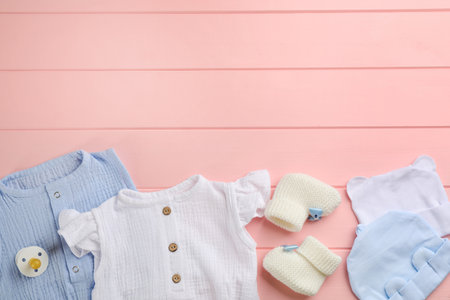 Flat lay composition with baby clothes and accessories on pink wooden background, space for textの写真素材