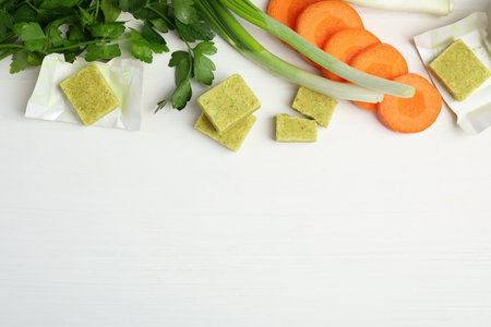 Bouillon cubes and other ingredients on white wooden table, flat lay. space for textの写真素材