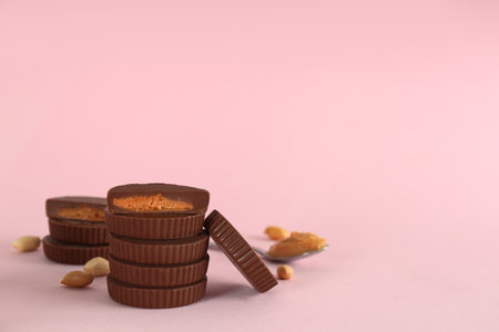 Sweet peanut butter cups on pink background. Space for textの写真素材