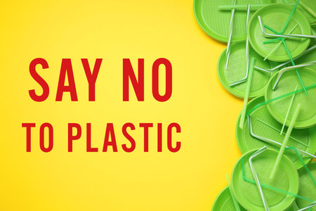 Text SAY NO TO PLASTIC and disposable dishware on yellow background, flat lay.の写真素材