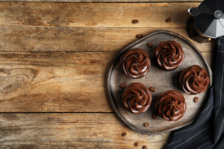 Flat lay composition with delicious chocolate cupcakes on wooden table. Space for textの写真素材