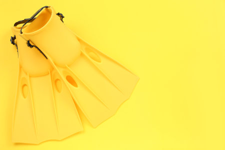 Pair of flippers on yellow background, flat lay. Space for textの写真素材