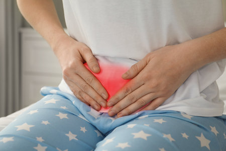 Woman suffering from abdominal pain at home, closeupの写真素材