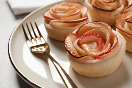 Freshly baked apple roses served on light table, closeup. Beautiful dessertの写真素材
