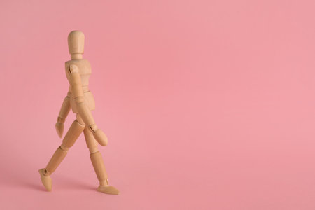 Wooden human model on pink background, space for text. Mini mannequinの写真素材