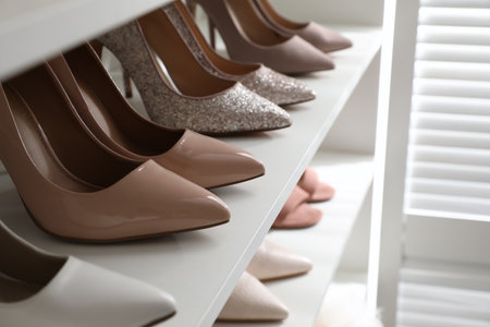 Different stylish women's shoes on shelf in dressing room, closeupの写真素材