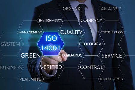 Businessman pointing at virtual icon with text ISO 14001 on color background, closeupの写真素材