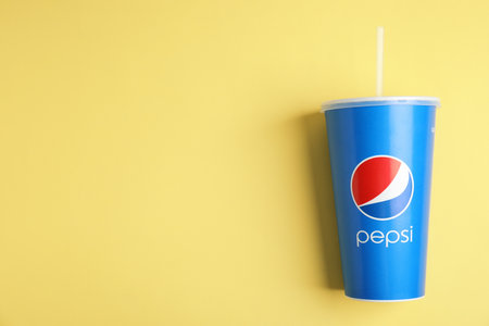 MYKOLAIV, UKRAINE - JUNE 08, 2021: Paper Pepsi cup on yellow background, top view. Space for textのeditorial素材