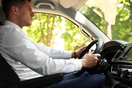 Handsome man driving his modern luxury carの写真素材