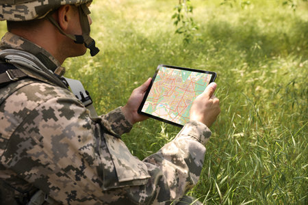 Soldier using tablet in forest. modern technologyの写真素材