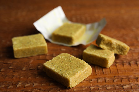 Bouillon cubes with wrap on wooden table, closeupの写真素材