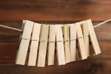Many clothespins on rope against wooden background, closeupの写真素材