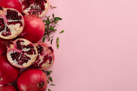 Flat lay composition with ripe pomegranates on pink background. Space for textの写真素材
