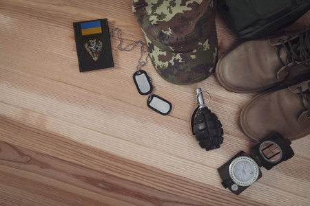 MYKOLAIV, UKRAINE - SEPTEMBER 26, 2020: Tactical gear and Ukrainian army patch on table, flat lay. Space for textのeditorial素材