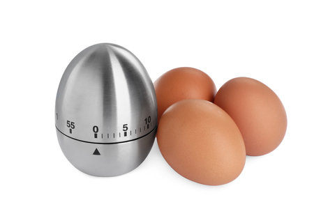 Kitchen timer and chicken eggs on white backgroundの写真素材