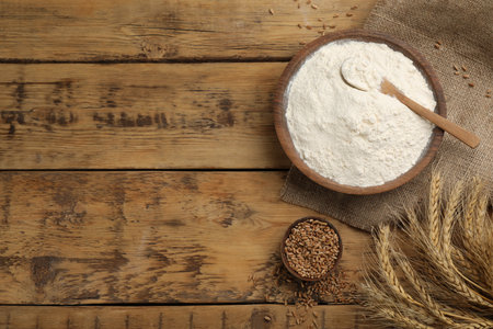 Flat lay composition with wheat flour on wooden table. Space for textの写真素材