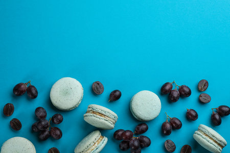 Flat lay composition with macarons and grapes on light blue background. Space for textの写真素材