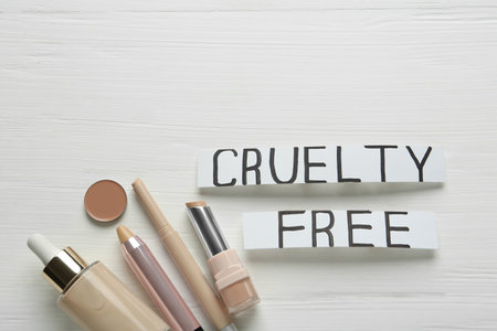 Flat lay composition with words Cruelty Free and different cosmetic products not tested on animals against white wooden backgroundの写真素材