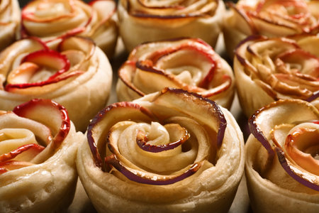 Freshly baked apple roses on parchment paper, closeup. beautiful dessertの写真素材