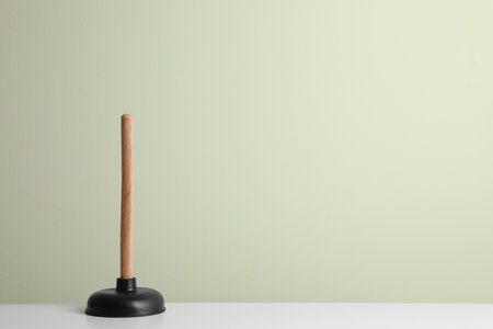 Plunger on white table against light background. Space for textの写真素材