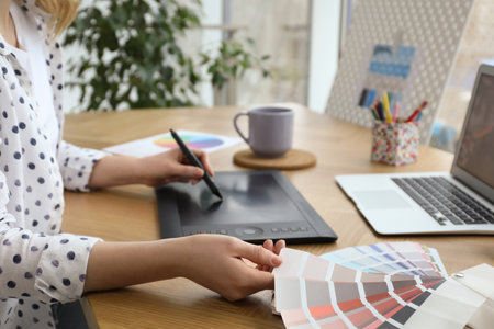 Professional designer with graphic tablet at wooden table, closeupの写真素材