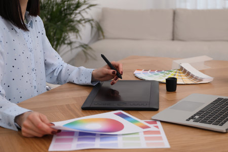 Professional designer with graphic tablet at wooden table, closeupの写真素材
