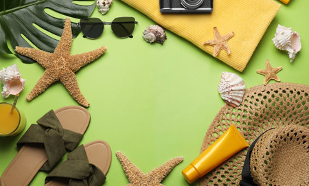 Frame of different beach objects on green background, flat lay. Space for textの写真素材