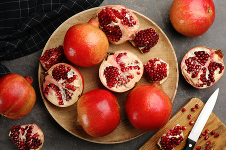Delicious ripe pomegranates on gray table, flat layの写真素材