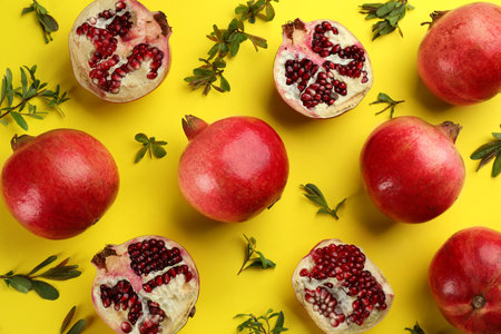Flat lay composition with ripe pomegranates on yellow backgroundの写真素材
