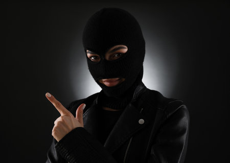 Woman wearing knitted balaclava on black backgroundの写真素材