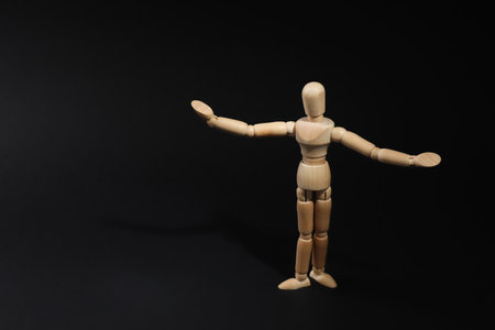 Wooden human model on black background, space for text. Mini mannequinの写真素材