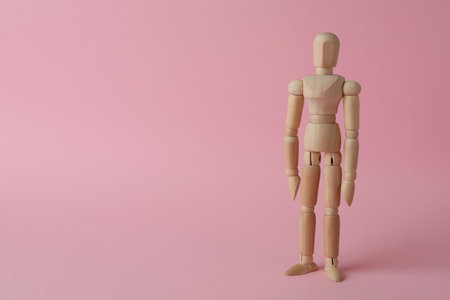 Wooden human model on pink background, space for text. Mini mannequinの写真素材