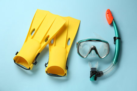 Pair of yellow flippers and mask on light blue background, flat layの写真素材