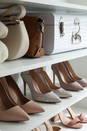 Stylish women's shoes, clothes and bags on shelving unitの写真素材
